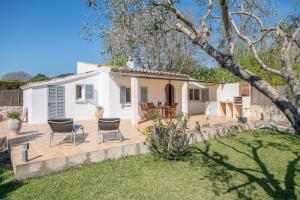 a white house with chairs and a yard at Ses Oliveres in Pollença