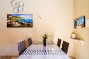 a table in a room with a painting on the wall at La rimesa di Tittì - Tittì in Alezio