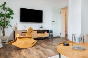 a living room with a tv and a wooden horse chair at Salem´s Treasure Manor in Salem
