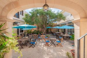 an outdoor patio with tables and blue umbrellas at Segles 11 in Campos