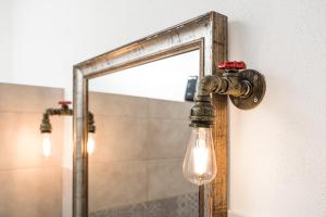a light bulb attached to a mirror in a bathroom at S' Istancu Vetzu in Irgoli +18 photos