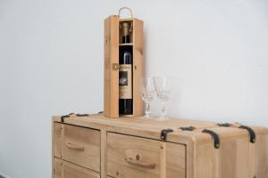 a bottle of wine and a wine glass on a dresser at S' Istancu Vetzu in Irgoli