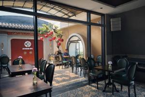 a restaurant with tables and chairs and a man sitting at a piano at Cao Boutique Hotel in Thôn Trường Giang