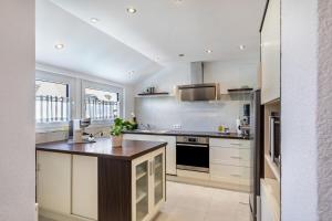 a kitchen with white cabinets and a wooden counter top at Ferienwohnug New Look in Geisenheim