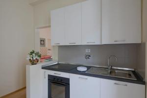 フィレンツェにあるProconsolo Superior Suiteの白いキャビネットとシンク付きのキッチン