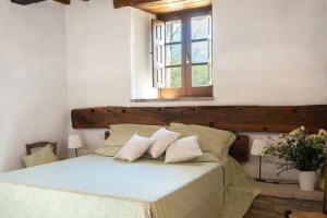 a bedroom with a bed with pillows and a window at Appartamento Stalla - Cortona in Corgna