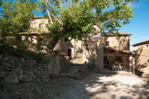 a stone house with two people sitting on chairs in front of it at Appartamento Stalla - Cortona in Corgna