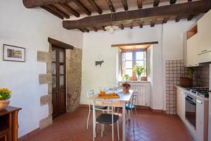 a kitchen and dining room with a table and chairs at Appartamento Stalla - Cortona in Corgna