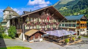 a building with tables and umbrellas in front of it at L'Auberge de L'Ours in Vers L'Eglise