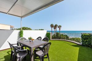 a patio with a table and chairs and the ocean at Casa Mar de frente in Málaga