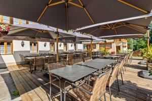 a group of tables and chairs with umbrellas on a deck at L'Auberge de L'Ours in Vers L'Eglise
