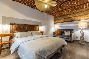 a bedroom with a large bed and a couch at Le Zucche Vuote in Quargnento