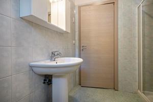 a bathroom with a sink and a mirror and a door at Appartamento Andromeda B2 in Bibione +16 photos