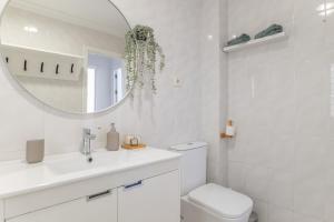 a white bathroom with a sink and a mirror at Apartamento a pie de playa in Barbate +16 photos