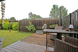 a wooden deck with a table and chairs and a fence at Lütte Hütte in Hennstedt