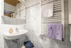 a white bathroom with a sink and a mirror at Ferienwohnung Zugspitze in Grainau +18 photos
