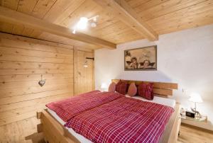 a bedroom with a large bed with a red blanket at Ferienwohnung Zugspitze in Grainau