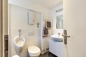 a bathroom with a toilet and a sink and a urinal at Wohnung 1 in Wallhausen +16 photos