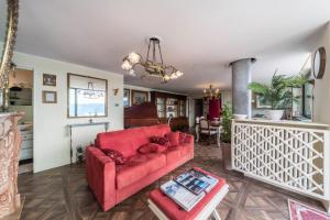 a living room with a red couch and a table at Resort Style Apartment in Perledo