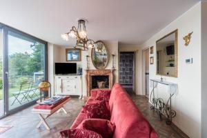 a living room with a red couch and a fireplace at Resort Style Apartment in Perledo