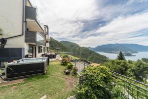 a house with a balcony with a boat on the yard at Resort Style Apartment in Perledo