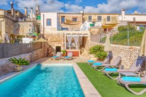 a villa with a swimming pool with chaise lounge chairs at Casa del Sol in Búger