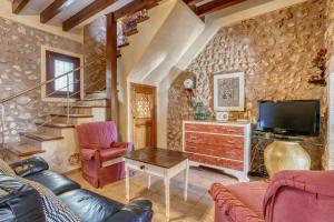 a living room with a couch and a tv at Casa del Sol in Búger