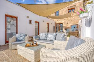 a patio with wicker chairs and a couch at Casa del Sol in Búger