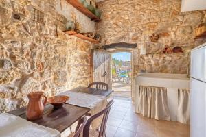a kitchen with a table and a stone wall at Casa del Sol in Búger