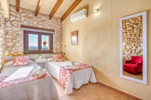 a room with two beds and a red chair at Casa del Sol in Búger +22 photos