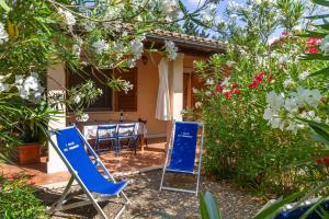 two blue chairs and a table in a garden at Bilo Erica in Marina di Grosseto