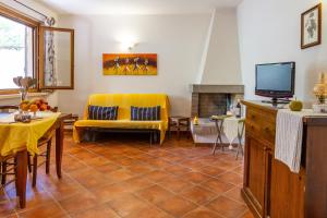 a living room with a yellow couch and a tv at Bilo Erica in Marina di Grosseto