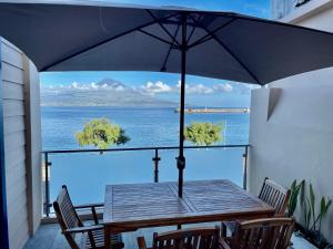 a table with an umbrella on a balcony with the ocean at Ladomar Matriz in Horta