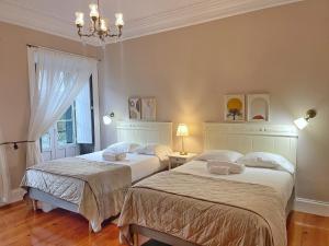 a bedroom with two beds and a chandelier at Ladomar Matriz in Horta