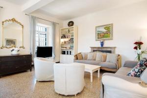 a living room with white furniture and a tv at Villa Mesco in Levanto