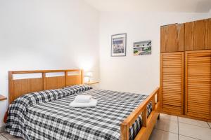 a bedroom with a bed with a black and white checkered blanket at La Capannuccia A in Ansedónia