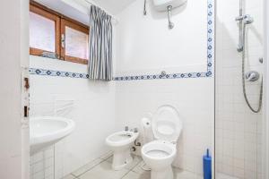 a bathroom with a toilet and a sink at La Capannuccia A in Ansedónia +5 photos