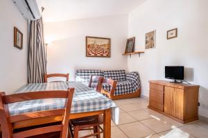 a living room with a table and a couch at La Capannuccia A in Ansedónia