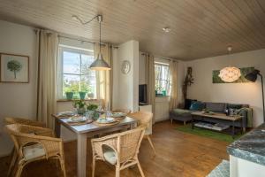 a dining room and living room with a table and chairs at Ferienhaus Landlust-Karsee in Wangen im Allgäu