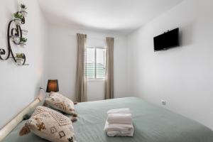 a white bedroom with a bed and a television at Casa Otilia in Arafo