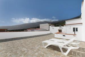 a pair of white chairs sitting on top of a roof at Casa Otilia in Arafo