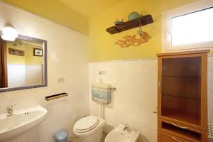 a bathroom with a toilet and a sink and a mirror at Casa Gelsomino in Imperia +20 photos