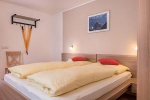 a bedroom with two beds with yellow sheets and red pillows at Hilber Fermeda in Villnoss