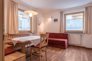 a living room with a table and a red couch at Hilber Fermeda in Villnoss