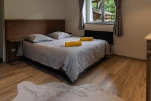 a bedroom with a bed with two yellow towels on it at Chalet La Sentinelle in Bellecombe