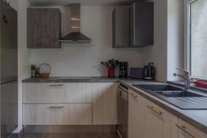 a kitchen with wooden cabinets and a sink at Chalet La Sentinelle in Bellecombe +18 photos