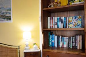 a book shelf filled with books next to a lamp at Casa Gelsomino in Imperia