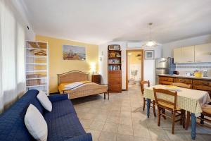 a living room with a blue couch and a kitchen at Casa Gelsomino in Imperia