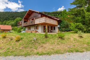 a house sitting on top of a lush green field at Chalet L'oréade in Manigod