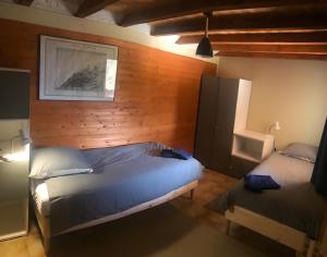 a bedroom with two beds and a wooden wall at Chalet L'oréade in Manigod
